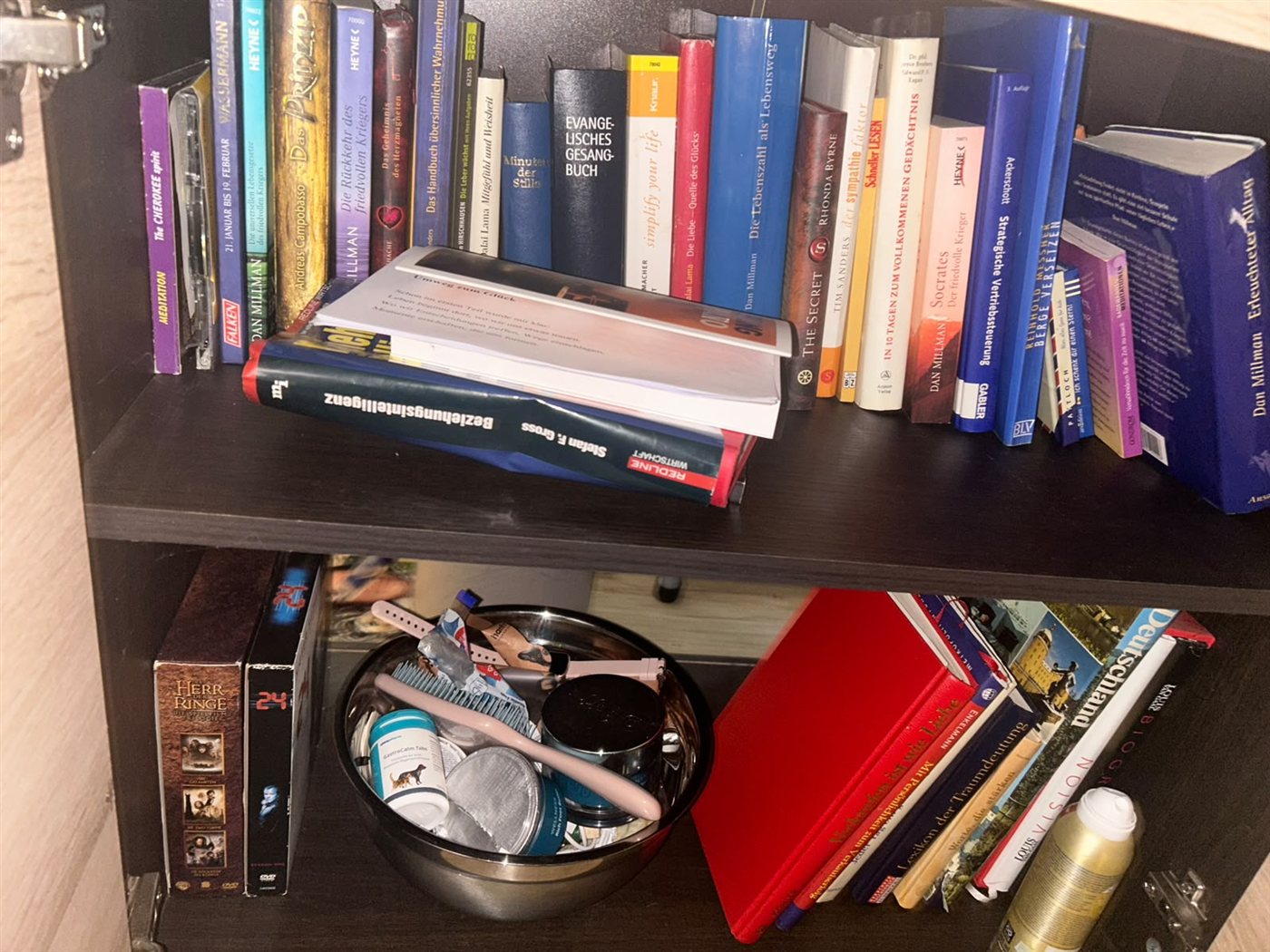 Persönliches Bücherregal von Klaus Heller mit Büchern, Notizen und Alltagsgegenständen